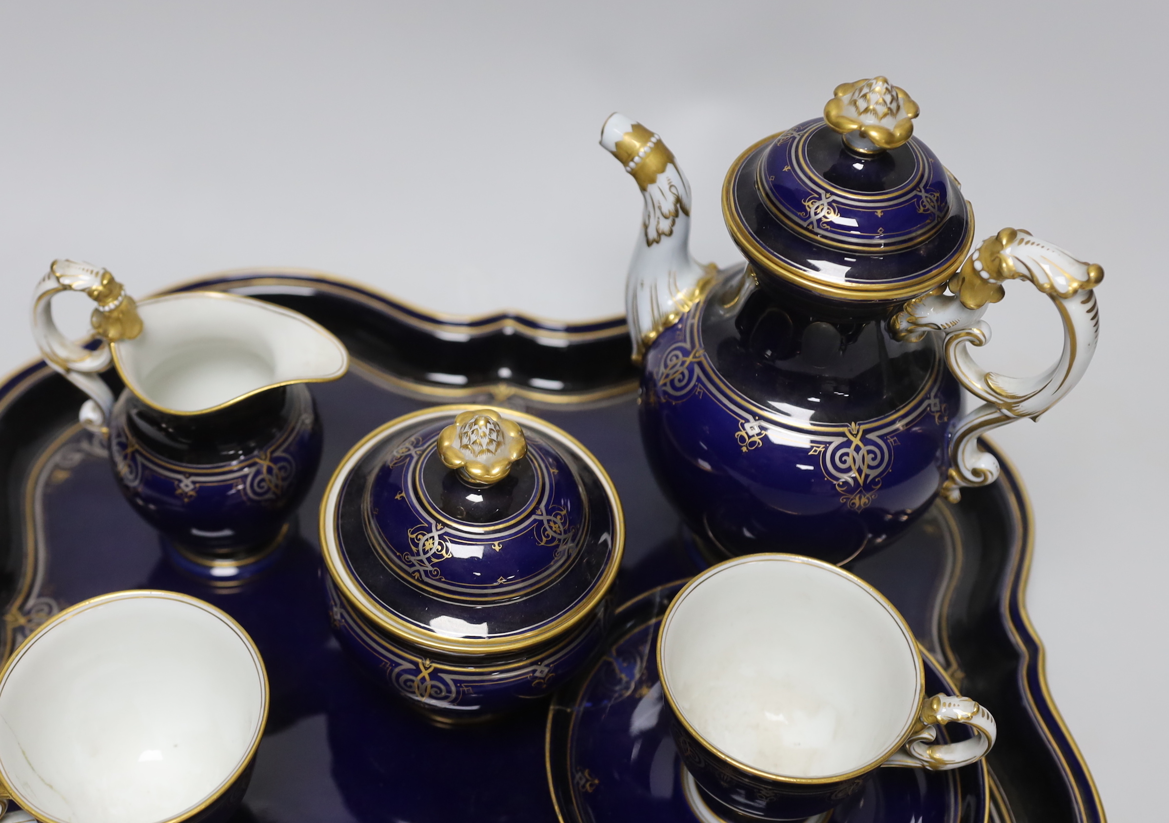 A late 19th century Meissen cabaret set comprising sugar bowl and cover, teapot and cover, creamer, two cups, a saucer and a tray (a.f.)
